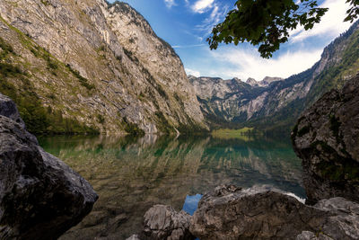 Scenic view of lake by mountains against sky