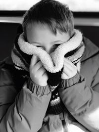 Close-up portrait of cute boy covering face
