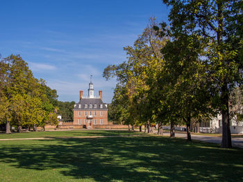 In historic colonial williamsburg, virginia, the governor's palace with its front lawn and blue sky.