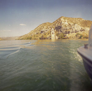 Scenic view of sea and mountains against clear sky