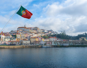 Flag by river against sky