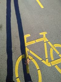 High angle view of yellow arrow symbol on road