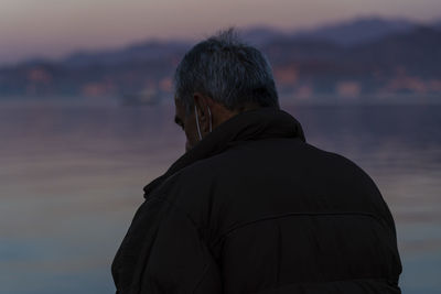 Rear view of man looking at sea against sky