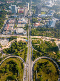 High angle view of road amidst trees and buildings in city