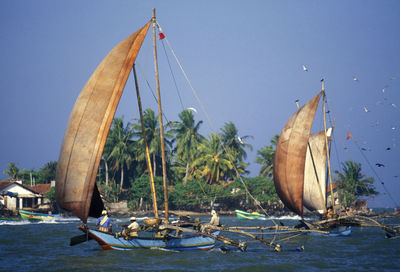 People in boat on sea against sky