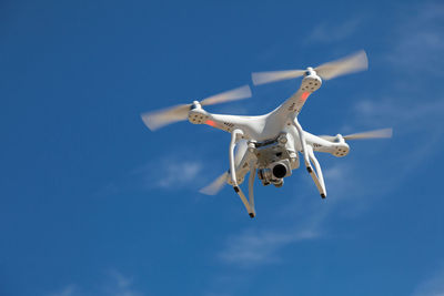 Low angle view of airplane flying against blue sky