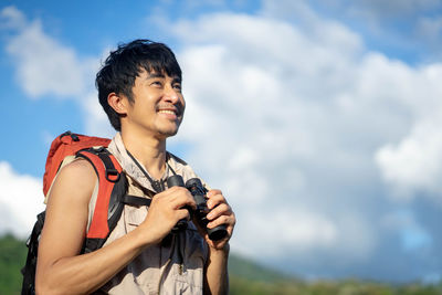 Side view of young man photographing with camera