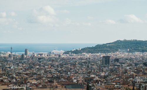 Cityscape by sea against sky