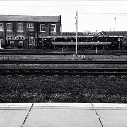 Railroad tracks amidst buildings against sky
