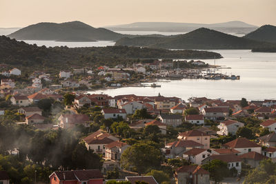 High angle view of townscape by sea against sky