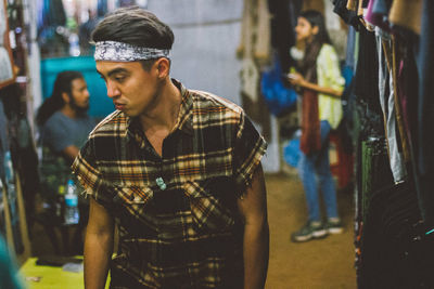 Side view of young man traveller standing in market 