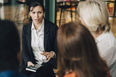 Businesswoman explaining colleagues in meeting at conference