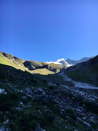 Scenic view of snowcapped mountains against clear blue sky