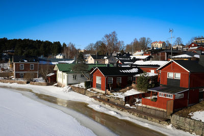 Houses and buildings in city against clear sky