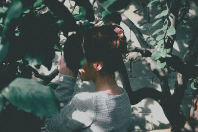 Side view of woman amidst branches