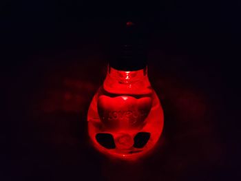 Close-up of illuminated red light against black background