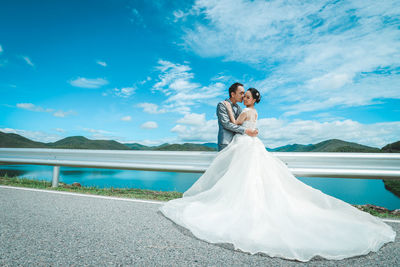 Rear view of couple kissing in park against sky