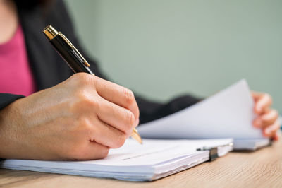 Cropped image of hand holding book on table