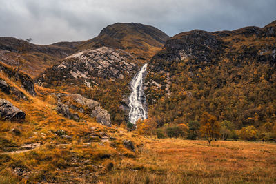 Scenic view of waterfall against sky