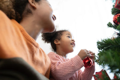 Rear view of friends looking at christmas tree