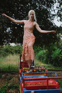 Young woman standing on miniature train