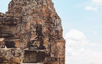 Low angle view of statue at historic temple against sky