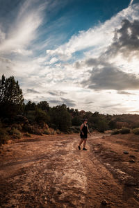 Rear view of man walking on street against sky