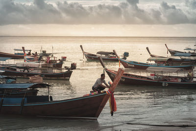 Boats moored in sea against sky