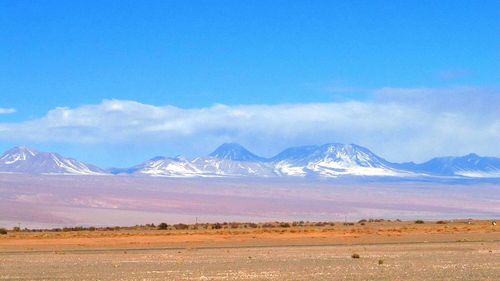 Scenic view of mountains against blue sky