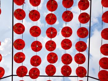 Low angle view of red decoration hanging against sky