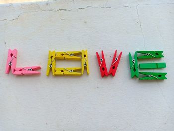 Close-up of multi colored clothespins hanging on wall