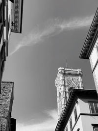 Low angle view of buildings against cloudy sky