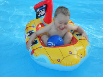 Close-up of boy on inflatable toy raft in swimming pool