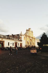 People at temple against sky in city