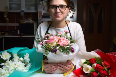 Florist shop. florist woman creating colorful flowers including roses and tulips, she arranges 