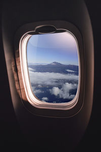 View of cloudy sky seen through airplane window