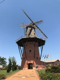 Low angle view of traditional windmill against clear blue sky