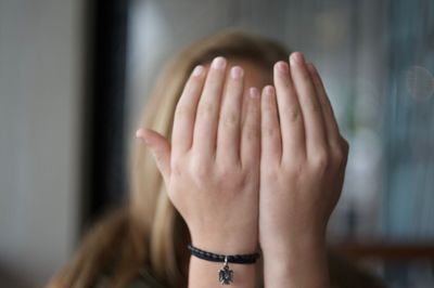 Close-up of woman covering face with hands