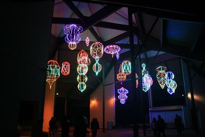 Low angle view of illuminated lighting equipment in city at night