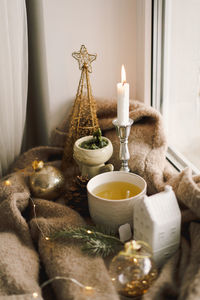 Hot tea, candles, christmas golden balls and decorations. christmas holiday mood.