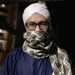 Portrait of man wearing sunglasses against black background