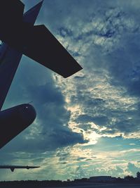 Low angle view of silhouette airplane against sky