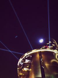 Low angle view of illuminated ferris wheel against sky at night