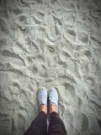 Low section of man standing on sand