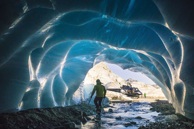 Ice climber retreats back to helicopter after a day of climbing.