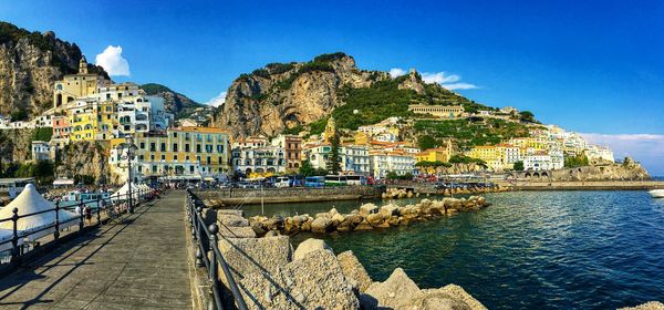 Scenic view of sea by town against sky