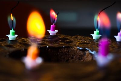 Close-up of illuminated candles on container