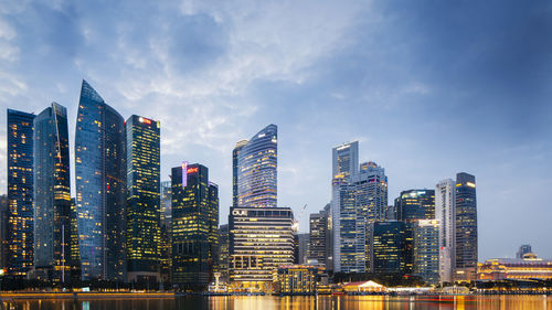 Illuminated buildings in city against sky