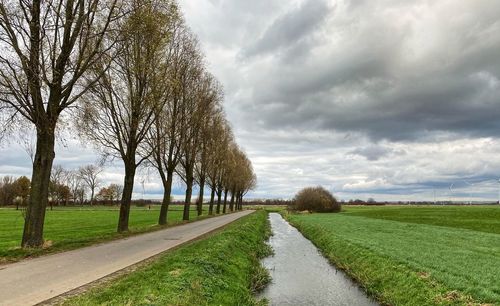 Road amidst field against sky