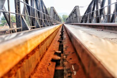 Railroad tracks by bridge against sky